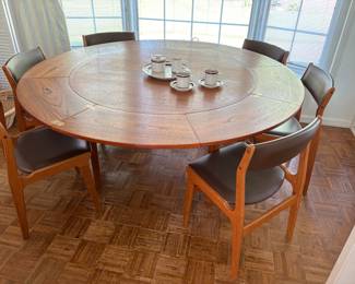 MCM round table with extentions that tuck under tabletop, sown with 6 MCM leather and wood chairs