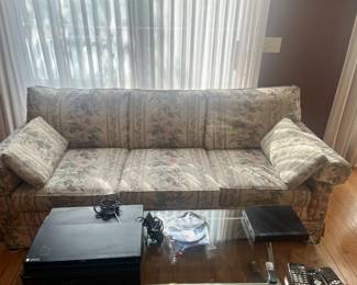 Living room floral sofa, glass and brass coffee table