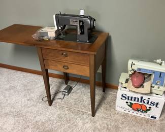 Kenmore machine in cabinet; Vintage Singer portable on right