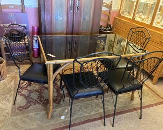 Glass top table with 4 iron chairs. This wuld work on a patio, Kitchen or smaller dining area