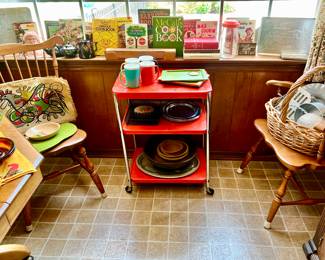 LOVE THIS ORANGE CART. NOTICE ALL OF THE VINTAGE COOKBOOKS.