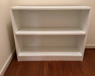 B21 - $15. White Shelf Unit. Pressed wood. Measures 37" wide x 11.5" deep x 29" tall. Sturdy - minor signs of use mostly on the bottom shelf.