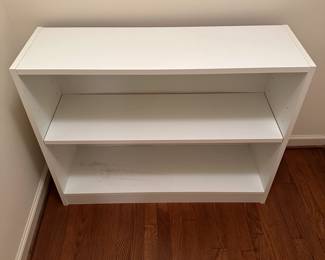 B21 - $15. White Shelf Unit. Pressed wood. Measures 37" wide x 11.5" deep x 29" tall. Sturdy - minor signs of use mostly on the bottom shelf.