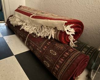 Many cleaned and rolled vintage rugs