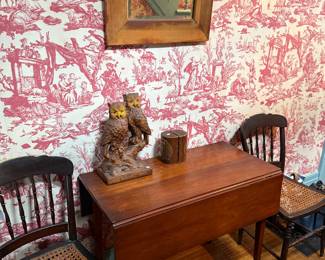 Absolutely a wonderful smaller size cherry drop leaf Hepplewhite table  Would work well behind a sofa as well.  Two of three caned chairs.  More owls and bookends.