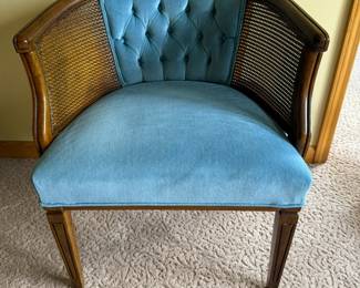 Vintage Barrell-Back Accent Chair mid-century
Description:
Style: The chair has a barrel-back shape with caned sides and a button-tufted backrest, suggesting a mid-20th-century design influence.
Material:
Frame: Wood, likely a stained hardwood.
Sides: Cane webbing.
Upholstery: The cushion and backrest are upholstered in a blue velvet or velour fabric.
Construction: The legs are straight and simple with light decorative insets, giving the piece a somewhat transitional look that fits both traditional and eclectic decor styles.