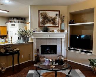 Artwork, half-moon side table, television & decor.