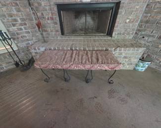 Outdoor fireplace items include metal tools and metal cushioned bench. Can with lid to right