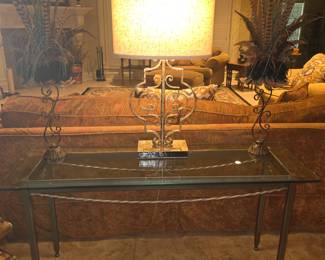 Glass top table behind sofa with lamp & decor