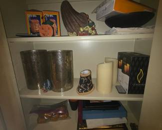 Items in shelf @ top = Halloween, 2nd = large round glass covers, small lampshade, 2 candles & box, 3rd = miscellaneous decor & frames
