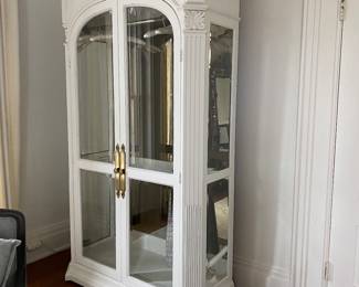 Large armoir with glass doors and side panels and mirrored back.