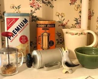 Vintage kitchen items: chopper jar, cracker tin, cooky press, pie bird, green Bauer #36 bowl