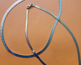 The top Silver Necklace has Dolphins Etched on it.