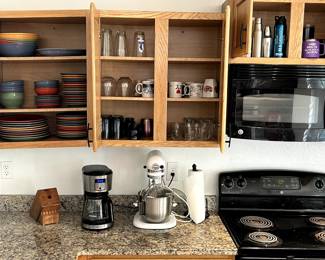 Coffee maker, knife block, paper towel holder, dishes, glasses, mugs, water bottles, etc.