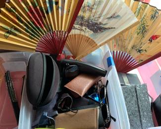 many pair of sunglasses, readers, glass cases and fans