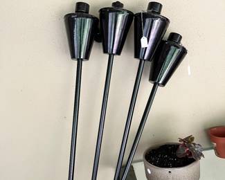Four tiki lights with large canisters