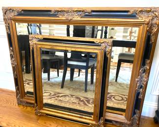 2 black and gold framed mirrors