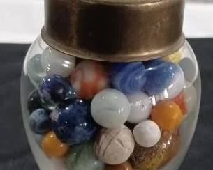 Apothecary show globe jar full of old marbles.