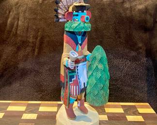 Hand carved and signed by the artist D. Adams Kachina doll. D. Adams is a well-known artist specializing in carving and painting Hopi kachina dolls. He is known for his work with Broadface Kachinas and other traditional Hopi kachina figures. His creations often feature hand-carved and painted details, and he is recognized for his authenticity and craftsmanship