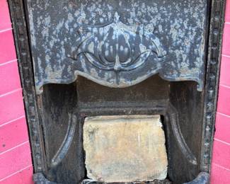 wrought iron fireplace with pink tiles