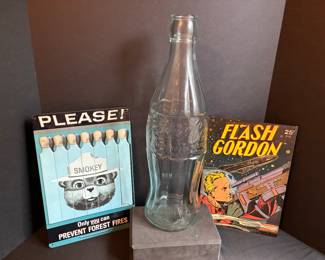 Giant Coca-Cola bottle and Smokey Bear, Flash Gordon metal signs