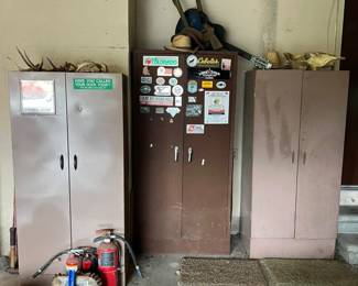 vintage metal storage cabinets with various stickers and signage. antlers and hunting decor on top. Fire extinguishers and cleaning tools nearby.