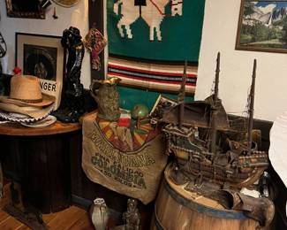 vintage wooden barrel, large wooden model ship, colorful woven textile wall hanging, assorted hats including straw hats, rare vintage "Marijuana Colombia" burlap sack, decorative pottery and statuettes