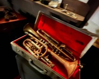 Various musical instruments. Pictured: Vintage brass trumpet in a lined hard case with a red interior.