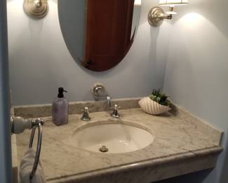 Floating marble top sink; vanity mirror; vanity lights