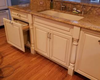 Base cabinets include a trash corral and a dishwasher