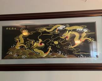 Framed piece of Chinese silk embroidery featuring two golden dragons chasing a flaming pearl.