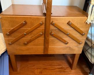 Vintage sewing or crafting table in a beautiful mid century modern wooden style full of supplies
