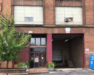 This is our entrance at the far N. end of the parking lot. Please take notice of the loading dock, fern planters & blue Donate Kids Books box. We are on the third floor and we will have a someone running the freight elevator up every 15 minutes or you can take the staircase to the left.
