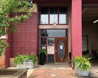 This is our entrance at the far N. end of the parking lot. Please take notice of the the fern planters, loading dock etc. We are on the third floor and we will have a someone running the freight elevator up every 15 minutes or you can take the staircase to the left.