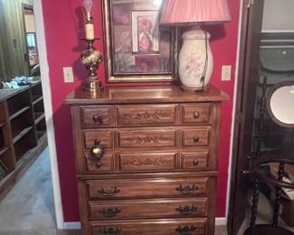 Located in red bedroom. This room has a queen size bedroom suite located in it. The pieces are about 50 years old (bought when we moved into the house). All the pieces are solid real wood. You don't buy quality like this anymore. Pictured is the chest of drawers. You also see two lamps and a wall picture.