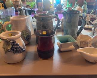 This table is located in the center of the living room. This picture shows the four pieces of Peppertown Pottery we have available for purchase. There is also a nice blue pottery pitcher, vintage vase and and two other collectable containers. Several additional items are available on the floor, including a box of vinyl albums and 45's.