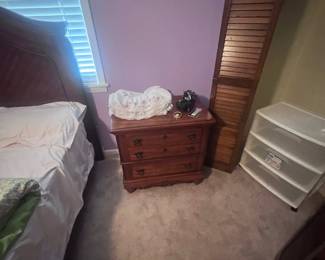 Nightstand that goes with bedroom suite. Plastic rolling storage container in closet.