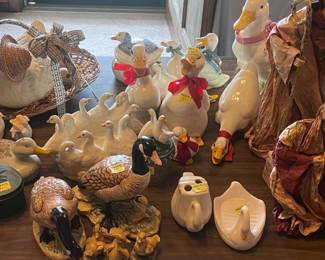 This table is located in the center of the living room. It contains an assortment of porcelain geese, swans, and ducks. There are more of these on the floor under the table.