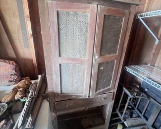 Located in garage. Vintage pie safe. The safe if missing the bottom doors. Two wooden straight back chairs.