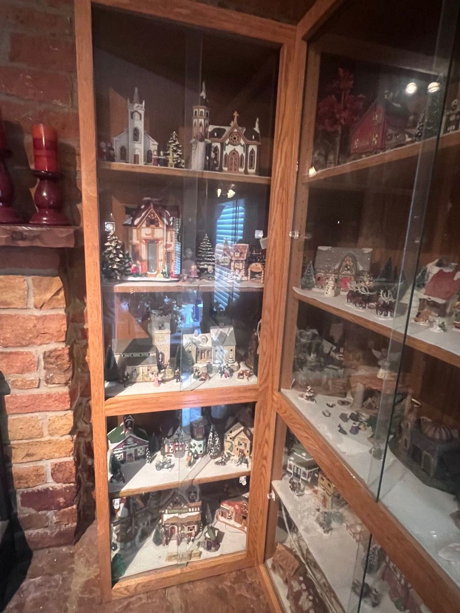 Cabinet #1 of the Christmas Village. There are 4 sliding glass cabinets with 5 shelves each. Many of the buildings and houses light up. It is really stunning to see it at night with everything lit up. The village has 50 larger pieces and lots of smaller houses, structures, people, and animals. This was our mother's favorite collectable.