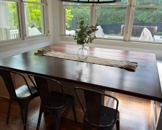 Solid wood custom breakfast nook table. Seats 12. Comes with a set of 4 modern metal chairs. Open storage base.