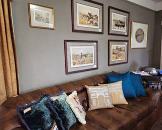 Chesterfield style brown vinyl sofa, as is, priced to sell. Double D velvet pillows on the far left. Four hunting scene lithographs with gray mats. There are other hunting scenes with green mats. Icart print "Lady of the Camelias" in far back.