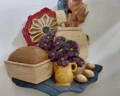 Cute kitchen decorative item, loaf of bread, cup of flowers, and fruit.
