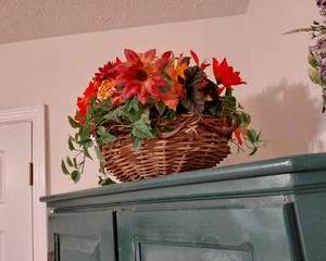 Artificial Flower Basket, Fall Colors, Reds, Oranges, & Greenery in Woven Basket.
