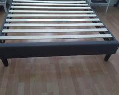 Queen size platform bedframe with slates includer, dark gray cloth on side rails.