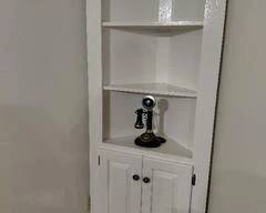 White Corner Cabinet with 3 shelves on top and 2 shelves inside closed area. 72"H x 28.5"W Vintage Phone not included, nice piece.