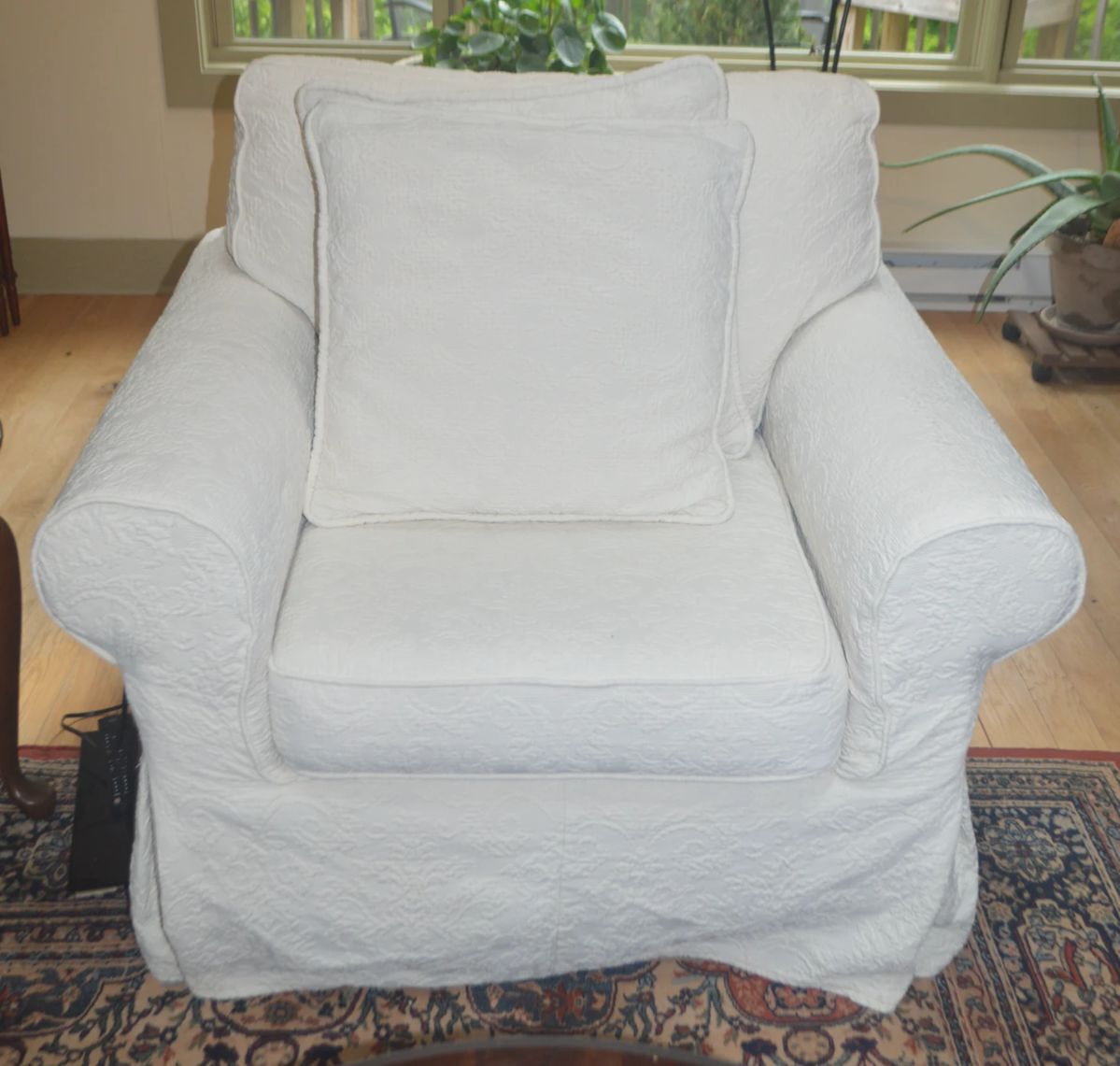 Comfy oversized chair with throw pillow and tailored slipcovers