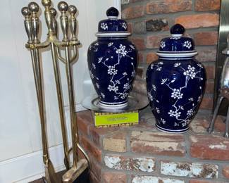 Blue and white ginger jars and brass fireplace tools.