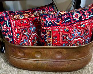 Antique hand hammered copper tub with brass handles. Two down tribal pillows.