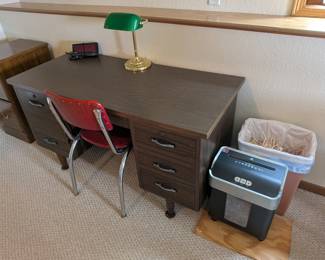 Charming Home Office Set: Desk, Chair & Lamp

Discover this functional and stylish set, perfect for creating an inviting workspace or study nook. This well-maintained desk offers ample surface area and drawer storage, complemented by a comfortable red chair that adds a pop of color. The classic green-shaded lamp provides ideal illumination, completing a cohesive look. An excellent opportunity to acquire a complete home office solution that combines practicality with attractive design.